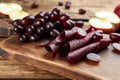 Delicious fruit leather rolls and grapes on wooden table, closeup