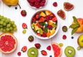 Delicious fruit salad and different fruits and berries on the white table Royalty Free Stock Photo