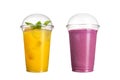 Delicious fruit smoothies in plastic cups, on a white background. Two cocktails with a taste of pineapple and wild berries