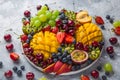 Delicious fruits and berries platter. Mango, kiwi, strawberry, grape, cherry, blueberry, peach and passion fruit