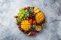 Delicious fruits and berries platter. Mango, kiwi, strawberry, grape, cherry, blueberry, peach and passion fruit