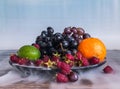 Delicious fruits salad in plate on table, lime, raspberry, grapes Royalty Free Stock Photo