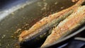 Delicious fryed fishes on hot frying pan. Royalty Free Stock Photo