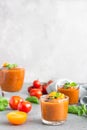 Delicious gazpacho soup in glass. Traditional spanish cold soup puree gaspacho garnish with tomato, cucumber and basil. Grey Royalty Free Stock Photo