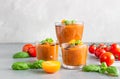 Delicious gazpacho soup in glass. Traditional spanish cold soup puree gaspacho garnish with tomato, cucumber and basil. Grey Royalty Free Stock Photo