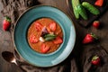 Delicious gazpacho soup with shrimps, strawberries and cucumber in bowl over brown wooden background. Healthy food, clean eating Royalty Free Stock Photo