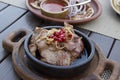 Delicious Georgian cuisine. fried meat in a clay pan, served with onions and pomegranate seeds