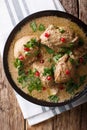 Delicious Georgian satsivi with chicken and pomegranate close-up in a bowl. Vertical top view