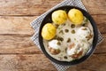 Delicious German meatballs in caper sauce served with boiled potatoes close-up in a plate. horizontal top view