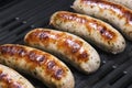 Delicious german sausages on the barbecue electro grill. Tasty sausages sizzling on a portable electric grilling on a summer