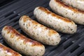 Delicious german sausages on the barbecue electro grill. Tasty sausages sizzling on a portable electric grilling on a summer
