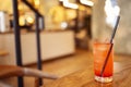 Delicious glass of red lemonade with ice cubes and a straw on a wooden backdrop Royalty Free Stock Photo