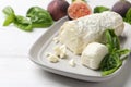 Delicious goat cheese with basil and figs on white wooden table Royalty Free Stock Photo
