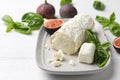 Delicious goat cheese with basil and figs on white wooden table Royalty Free Stock Photo