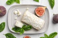 Delicious goat cheese with figs and basil on white wooden table, flat lay Royalty Free Stock Photo