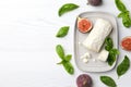 Delicious goat cheese with figs and basil on white wooden table, flat lay. Space for text Royalty Free Stock Photo