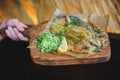 Delicious golden batter deep fried fish fillets, served on white plate on old dark wooden worktop, view from above Royalty Free Stock Photo