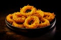 Delicious golden battered, breaded and deep fried crispy onion rings on black wooden table