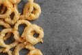 Delicious golden breaded and deep fried crispy onion rings on gray background, top view Royalty Free Stock Photo