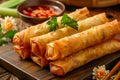 Delicious Golden Brown Fried Spring Rolls on Wooden Table with Sauce and Greens Royalty Free Stock Photo