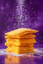 Delicious Golden Cheddar Cheese Crackers Piled with Falling Salt on a Vibrant Purple Background