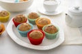 Delicious golden, homemade muffins with colorful paper cups, in a plate on a white background Royalty Free Stock Photo