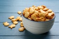 Delicious goldfish crackers in bowl on blue table