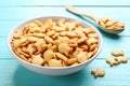 Delicious goldfish crackers in bowl on blue wooden table