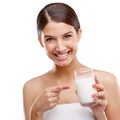 Delicious and good for you. Studio portrait of an attractive young woman pointing to the glass of milk shes holding. Royalty Free Stock Photo