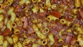 Goulash and noddles simmering in a red skillet