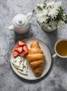 Delicious gourmet breakfast, brunch, snack - green tea, strawberries, croissant and gorgonzola cheese on a gray background, top Royalty Free Stock Photo