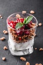 Delicious granola with yogurt and cherry in glass on black background. Royalty Free Stock Photo