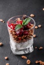Delicious granola with yogurt and cherry in glass on black background. Healthy breakfast ingredients. Clean eating Royalty Free Stock Photo