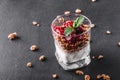 Delicious granola with yogurt and cherry in glass on black background. Healthy breakfast ingredients Royalty Free Stock Photo