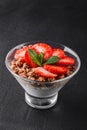 Delicious granola with yogurt and fresh strawberry in glass on black background. Healthy breakfast ingredients Royalty Free Stock Photo