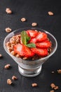 Delicious granola with yogurt and fresh strawberry in glass on black background. Healthy breakfast ingredients Royalty Free Stock Photo