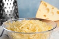 Delicious grated cheese in glass bowl