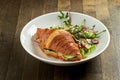 Delicious and great breakfast - croissant sandwich with salmon, cream cheese and cucumber with mixed salad, served in a white bowl Royalty Free Stock Photo