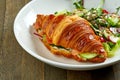 Delicious and great breakfast - croissant sandwich with salmon, cream cheese and cucumber with mixed salad, served in a white bowl Royalty Free Stock Photo