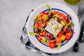 Delicious Greek salad with feta cheese, olives, tomatoes, cucumbers, paprika and red onions. Royalty Free Stock Photo
