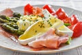 Delicious green boiled asparagus, ham, prosciutto, grape tomatoes, poached organic egg and brie cheese Royalty Free Stock Photo