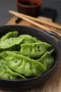 Delicious green dumplings (gyozas) on wooden table, closeup