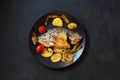 Delicious grilled dorado or sea bream fish with salad, spices, grilled dorada on a black plate. Top view, overhead, copy space Royalty Free Stock Photo