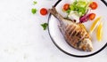 Delicious grilled dorado or sea bream fish with salad, spices, grilled dorada on a plate. Royalty Free Stock Photo