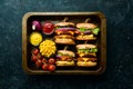 Delicious grilled homemade burgers with beef, tomatoes, cheese, onions and salad. Burger menu. Royalty Free Stock Photo