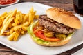 Delicious grilled homemade hamburger with beef, tomatoes, cheese, and lettuce on rustic wooden background Royalty Free Stock Photo