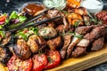 Delicious grilled meat with vegetable. Mixed grilled bbq meat with vegetables on wooden platter. Restaurant menu, dieting, Royalty Free Stock Photo