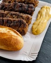 Delicious grilled minced meat rolls mici ori mititei traditional romanian and balkan dish served with mustard and bread on cardboa Royalty Free Stock Photo
