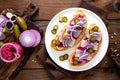 Delicious grilled sandwiches with herring, onion and beetroot sauce with horseradish on dark wooden rustic background. Danish cuis