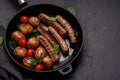 Delicious grilled sausages and potatoes in a sizzling frying pan Royalty Free Stock Photo